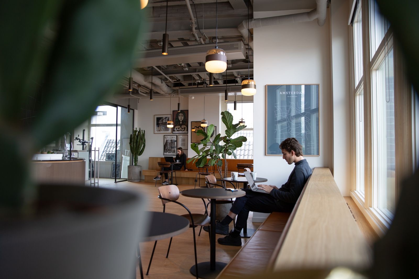 A laptop on a desk by the window of a small office