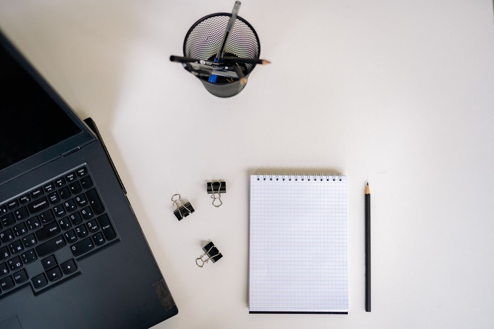 Binders, a laptop and a printed checklist on a desk as an application file is put together