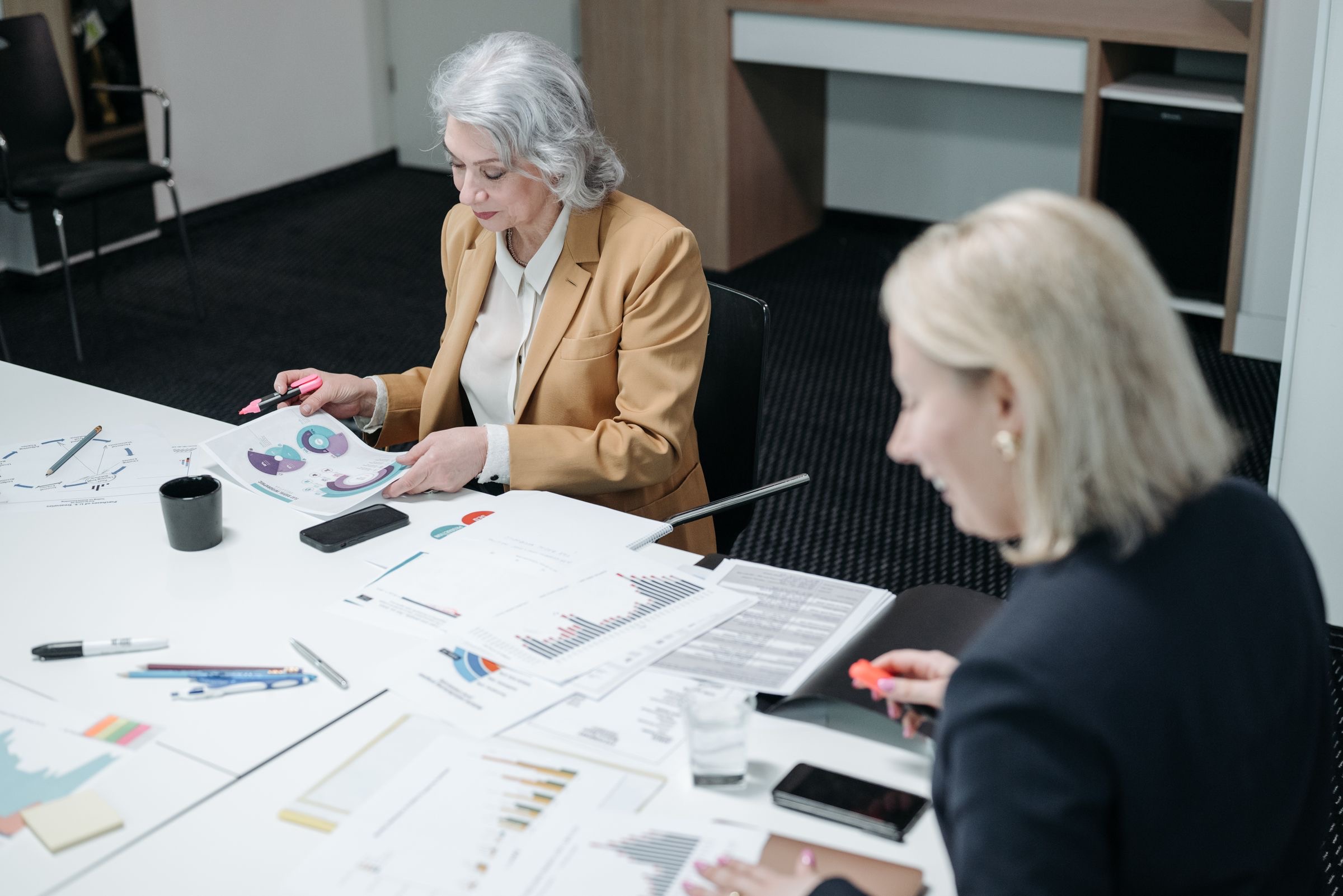 Two advisers reviewing a group ownership chart at a meeting table