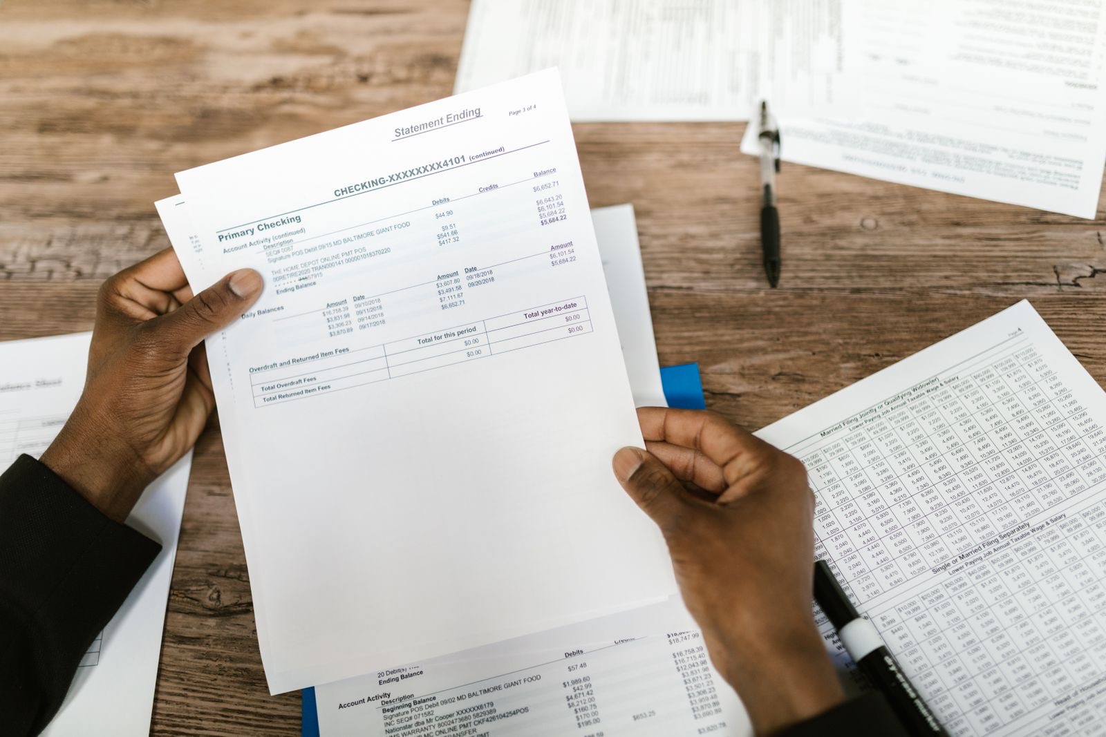 A bank statement and a notarial file side by side on a desk, prepared for the deed of incorporation