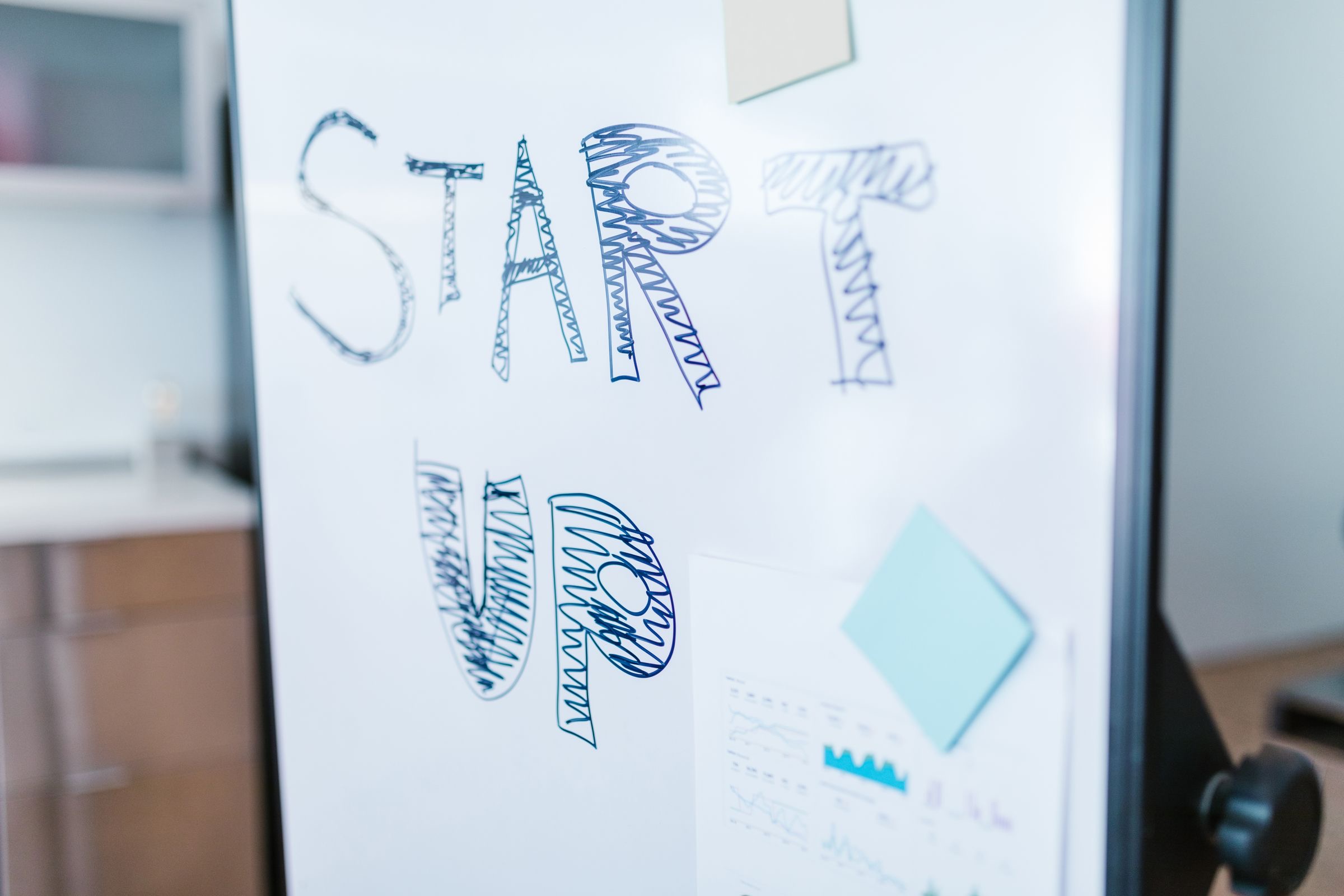 Founders planning at a whiteboard in a bright start-up office.