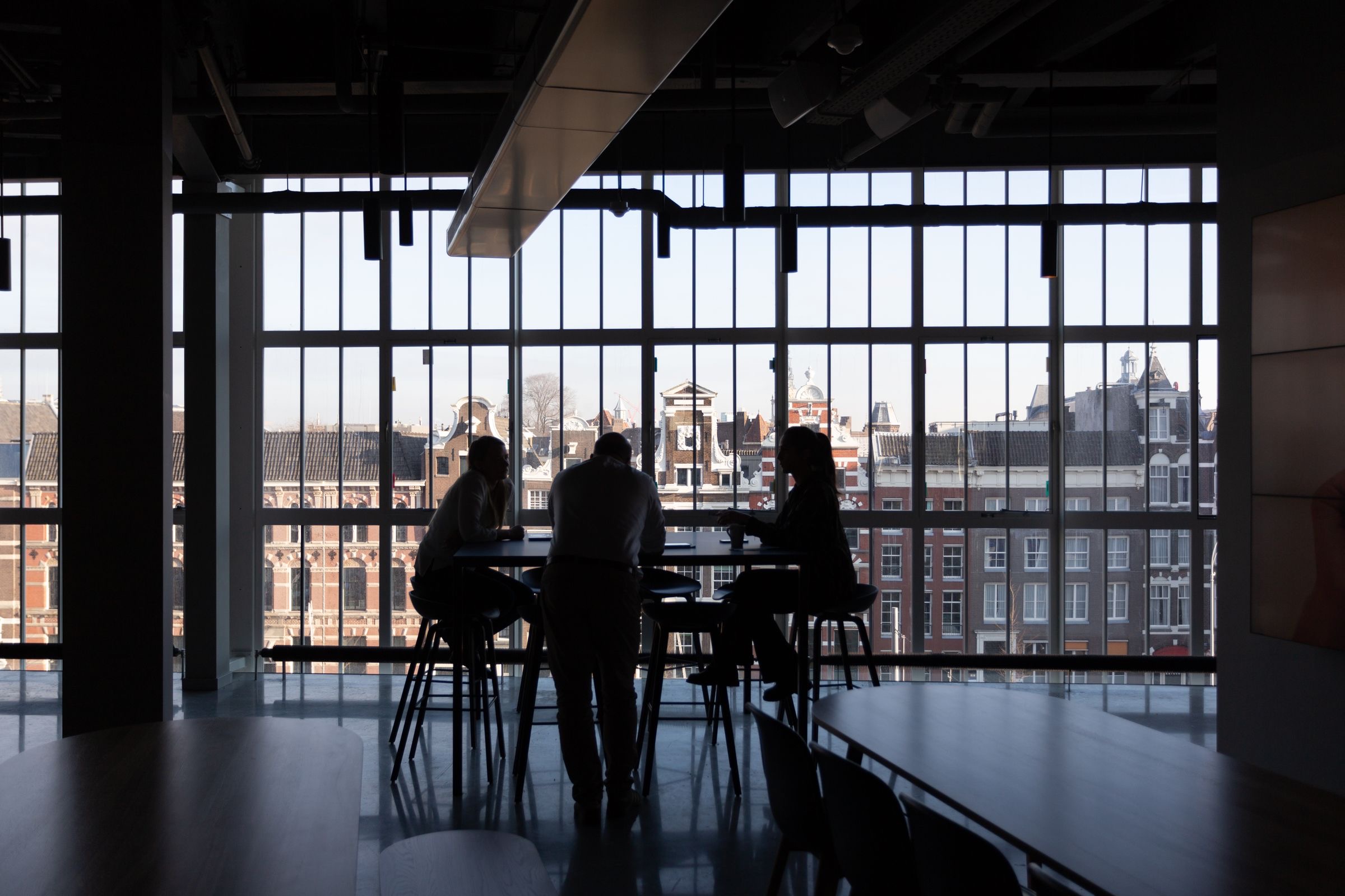 Board members around a meeting table in an Amsterdam office with a canal view